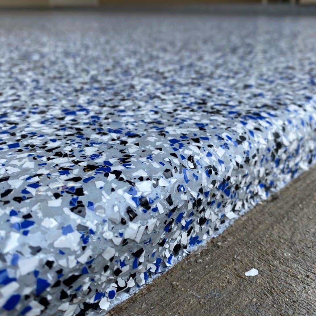 Close-up view of a textured surface with a speckled pattern of blue, white, and black fragments.